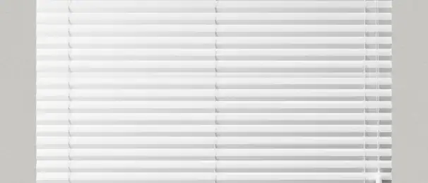 White horizontal window blinds installed on a large window, showcasing a modern alternative to curtains for light and privacy control.